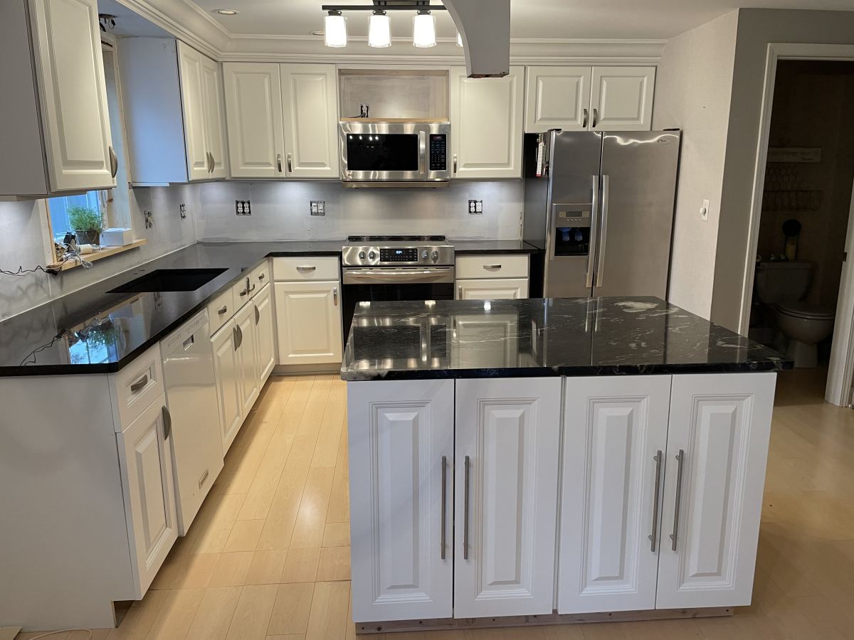 White kitchen with black granite countertops and island